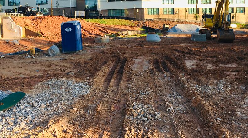 Work began this spring on redeveloping the former AT&T parking lot and storage area into a residential-only development of 136 units. In the foreground is the outline for extending New Street 250 feet and emptying in front of the new Talley Street Upper Elementary School. For the next month Talley Street which fronts the school will be closed as the developer connects its storm, sewer and water lines to the municipal system. Bill Banks file photo for the AJC