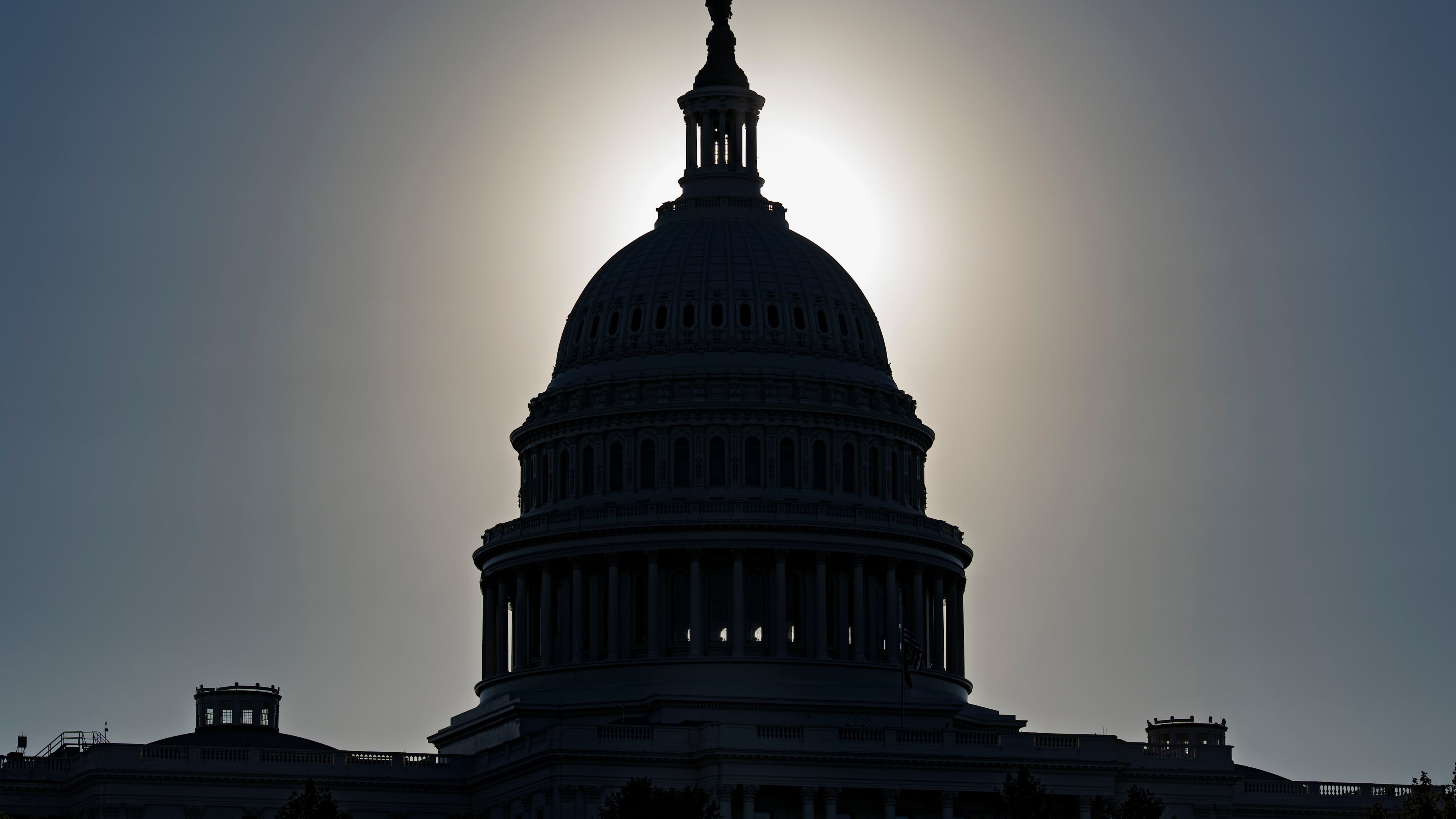 The U.S. Capitol is silhouetted by the stark glare of the morning sun as a government shutdown begins its tenth day, in Washington, Friday, Oct. 10, 2025. (AP Photo/J. Scott Applewhite)