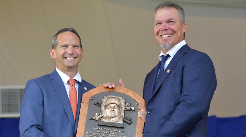 Chipper Jones shows off some new hardware to go on the wall at the Baseball Hall of Fame. He's joined by Jeff Idelson, the Hall's president. (HYOSUB SHIN / HSHIN@AJC.COM)