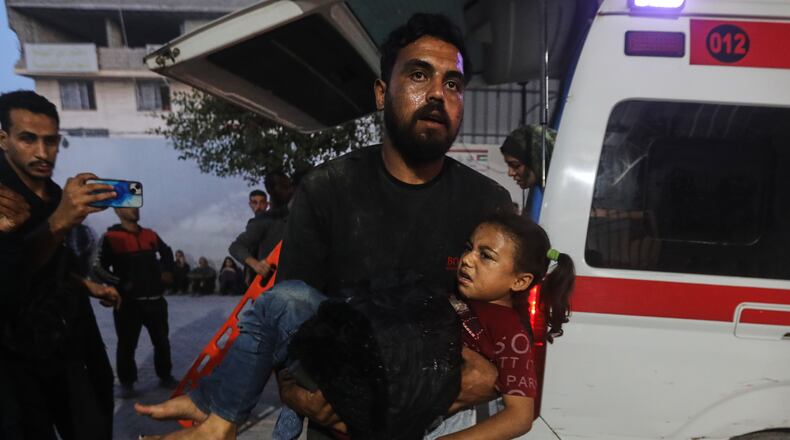 A Palestinian man carries a wounded girl into al-Shifa Hospital following Israeli strikes on the Gaza Strip, Saturday, Nov. 22, 2025. (AP Photo/Yousef Al Zanoun)