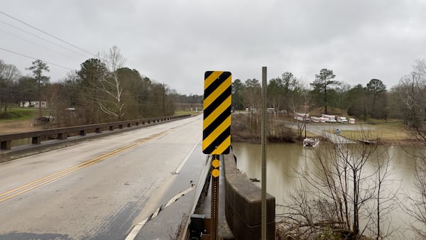A barren signpost at the edge of the Murder Creek bridge along U.S. 129 near Lake Sinclair, a post that once held a road sign bearing the stream's name. (Joe Kovac Jr. / AJC)