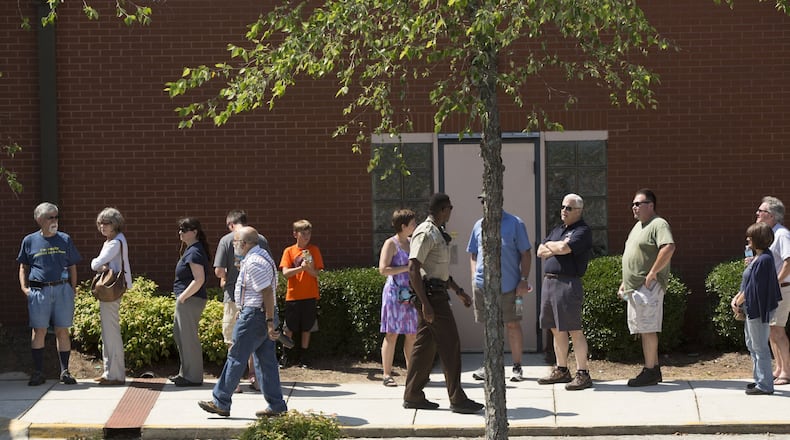 An officer walks outside the East Cobb Government Service Center in Cobb County on Saturday during early voting ahead of Georgia’s 6th Congressional District runoff on June 20. CHAD RHYM/AJC