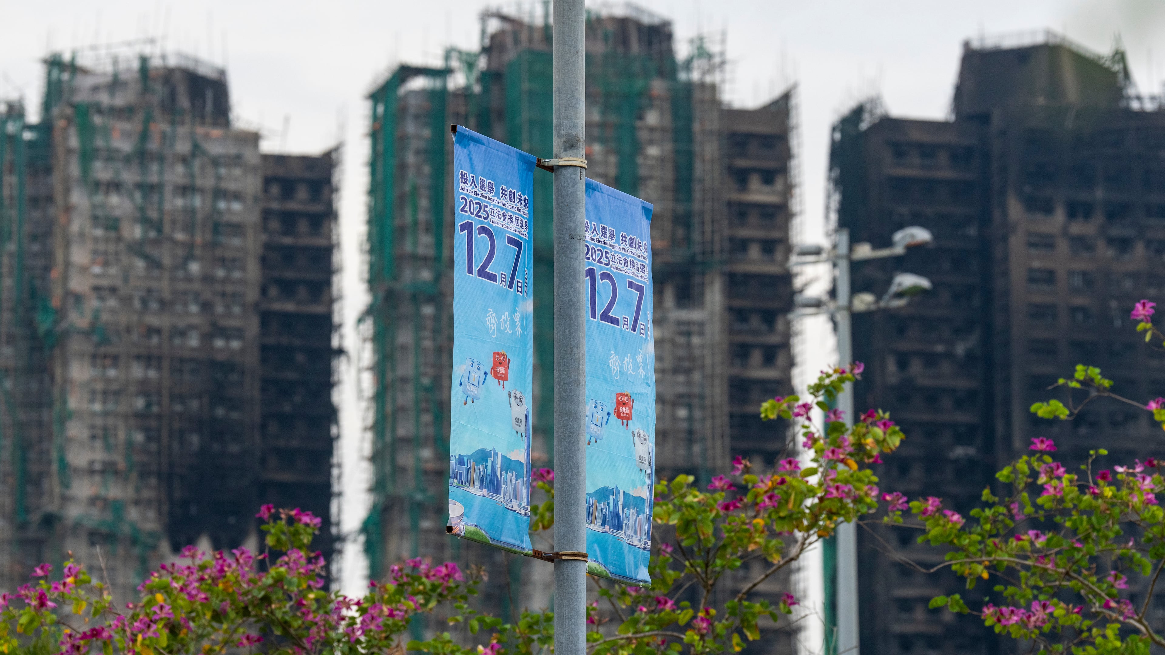 Banners promoting the Hong Kong Legislative Council General Election hang near the site of the fire at Wang Fuk Court in the Tai Po district of Hong Kong on Wednesday, Dec. 3, 2025. (AP Photo/Chan Long Hei)