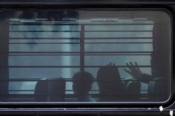 FILE - A family from Cuba is detained and loaded onto a bus with tinted windows and bars following an appearance at immigration court, June 11, 2025, in San Antonio. (AP Photo/Eric Gay, File)