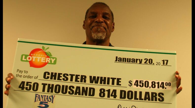 Chester White of Marietta poses with his lottery check Jan. 20, 2017. He won half of the $901,628 jackpot.