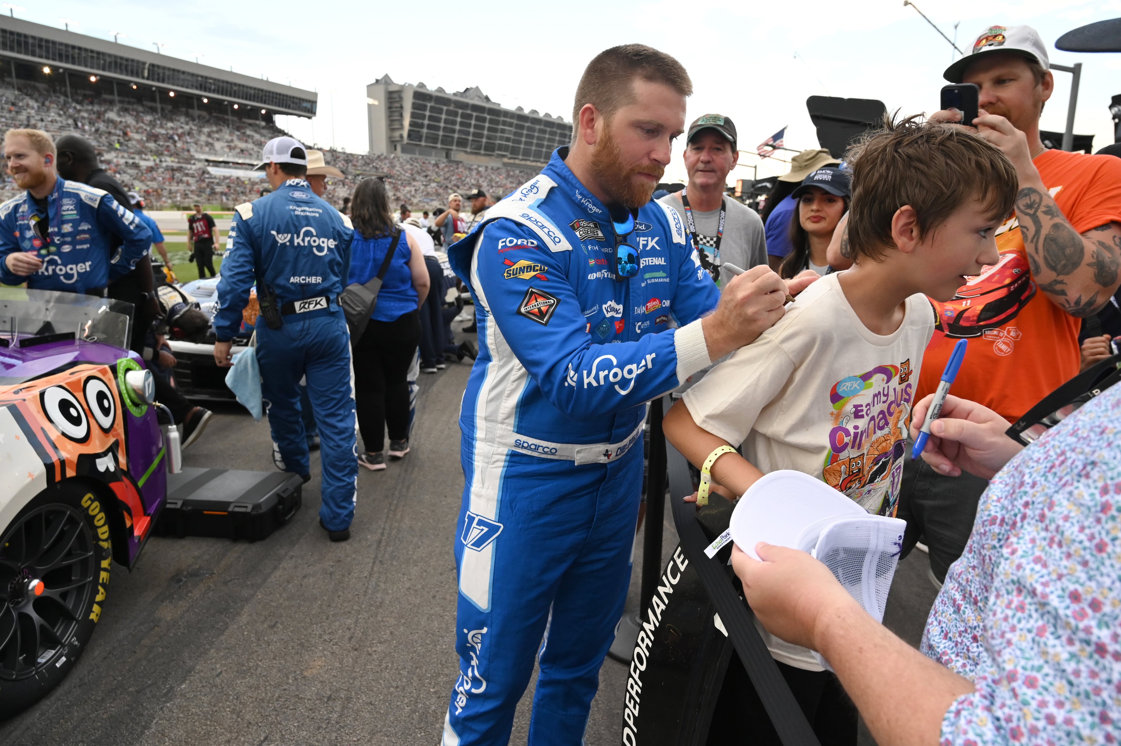 NASCAR Cup Series driver Chris Buescher signs an autograph before Quaker State 400 NASCAR Cup Series race at EchoPark Speedway, Saturday, June 28, 2025, in Hampton. (Hyosub Shin / AJC)