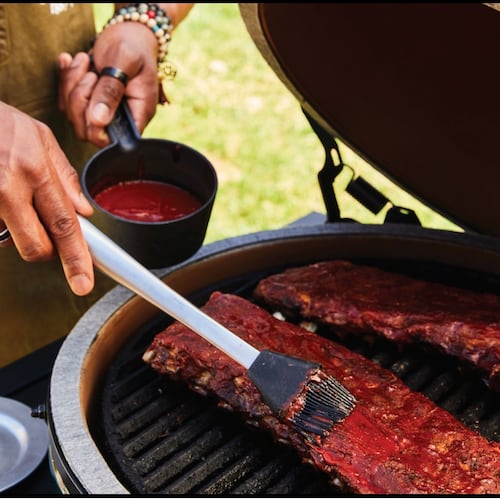 Grill master David Rose adds sauce to his BBQ ribs.