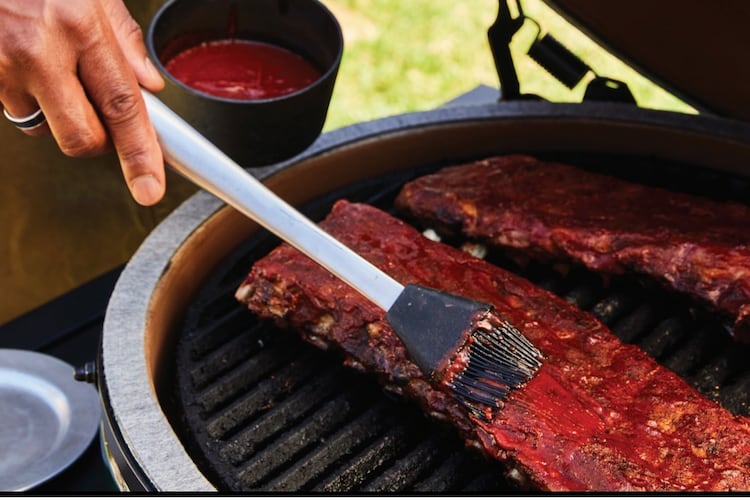Grill master David Rose adds sauce to his BBQ ribs.