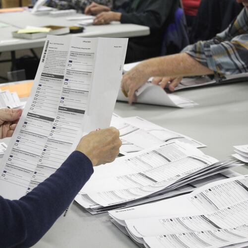 FILE - An election worker examines a ballot at the Clackamas County Elections office May 19, 2022, Oregon City, Ore. (AP Photo/Gillian Flaccus, File)