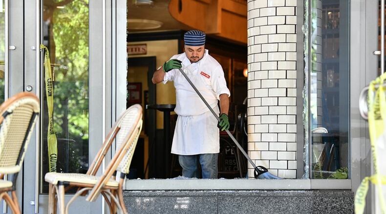 An employee cleans up after a night of riots and looting in Buckhead area at Bistro Niko restaurant on Peachtree Road in Buckhead. AJC Photo: Hyosub Shin