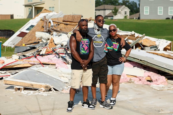 Tray, left, and Ayesha Chaney pose for a photograph with their 19-year-old son, Malachi, center, as they returned to their Henry County home for the first time after it was destroyed by an EF-2 tornado, Wednesday, June 25, 2025, in Locust Grove, Ga. (Jason Getz/AJC)