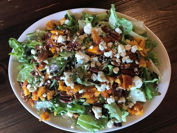 The house salad at Fire Stone Wood Fired Pizza & Grill is a delicious combination of mixed greens, dried peaches, candied pecans and blue cheese tossed in apple cider vinaigrette / Photo: Ligaya Figueras