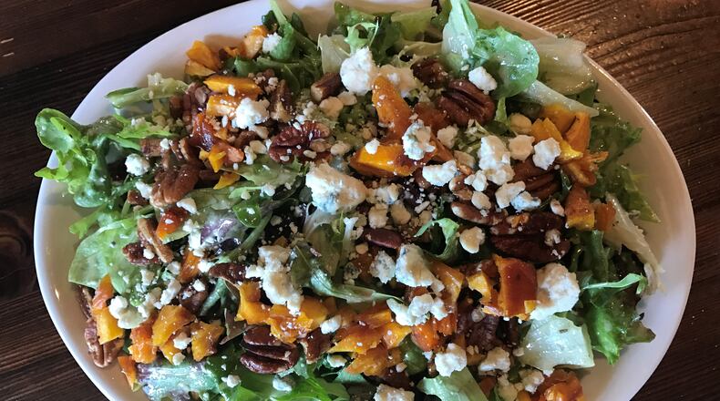 The house salad at Fire Stone Wood Fired Pizza & Grill is a delicious combination of mixed greens, dried peaches, candied pecans and blue cheese tossed in apple cider vinaigrette / Photo: Ligaya Figueras