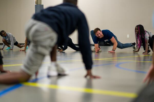 Volunteer Zac Potter doesn't mind getting down on the floor as he leads movement classes during a City of Refuge after-school program. Potter said service is part of his faith, and he is committed to showing up for the kids every Wednesday afternoon. He was named a "Difference Maker" by Gas South. (Courtesy of Gas South)