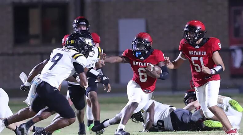 Bryan County's Erin Greene looks to throw a stiff-arm to East Laurens defender, Kyan Snead during Friday night's game at Bryan County High School.
Richard Burkhart/Savannah Morning News