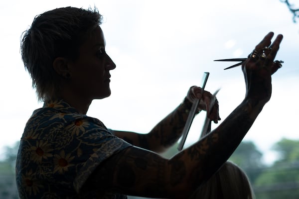 A silhouette of stylist Keenan Artelli cutting hair at Keenan Salon in Atlanta on Thursday, June 18, 2026. (Ben Gray for the AJC)