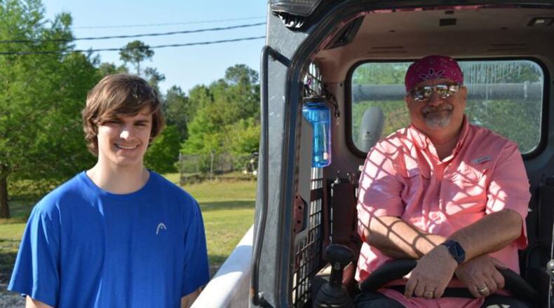 Grant Johnson, left, works on his Eagle Scout project under the watchful eye of his Scout Master - and dad - Mike Johnson at St. Teresa's School. (Courtesy of Carlton Fletcher)