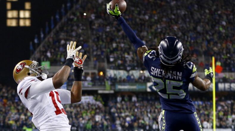 SEATTLE, WA - JANUARY 19: Cornerback Richard Sherman #25 of the Seattle Seahawks tips the ball up in the air as outside linebacker Malcolm Smith #53 catches it to clinch the victory for the Seahawks against the San Francisco 49ers during the 2014 NFC Championship at CenturyLink Field on January 19, 2014 in Seattle, Washington. (Photo by Jonathan Ferrey/Getty Images)