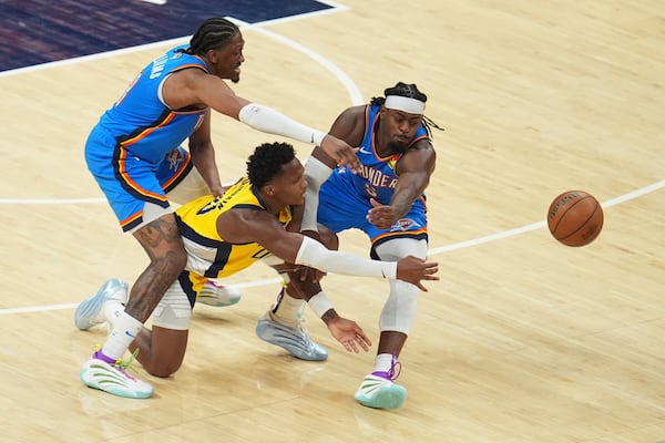 Indiana Pacers guard Bennedict Mathurin passes the ball under pressure from Oklahoma City Thunder forward Jalen Williams, right, during the second half of Game 3 of the NBA Finals basketball series, Wednesday, June 11, 2025, in Indianapolis. (AP Photo/Michael Conroy)
