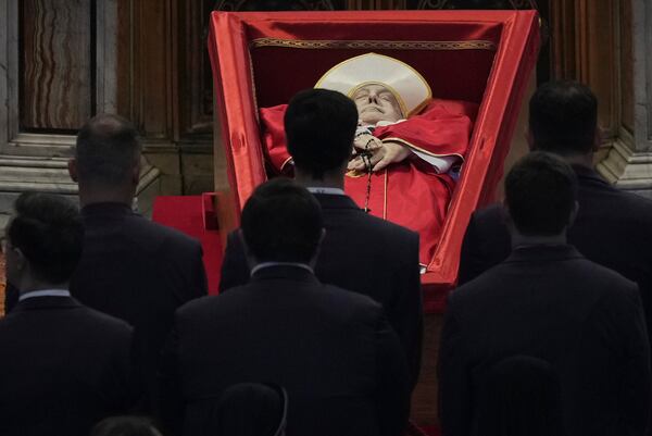 Vatican personnel pay their respects to Pope Francis inside St. Peter's Basilica at the Vatican, Wednesday, April 23, 2025, where his body will lie in state for three days. (AP Photo/Andrew Medichini, Pool)