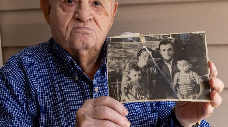 Holocaust survivor Hershel Greenblat holds up a photo of his sister Anne (from left), mother Mania, father Abraham and himself at his home in Grayson, Georgia. He was born in a cave in Ukraine in 1941, then fled with his parents inside a packed cattle car. He immigrated to the U.S. at age 8, and settle in Atlanta. Greenblat will be the featured speaker at the next Bearing Witness program, Sunday, Jan. 15, at The Breman Museum. PHIL SKINNER FOR THE ATLANTA JOURNAL-CONSTITUTION