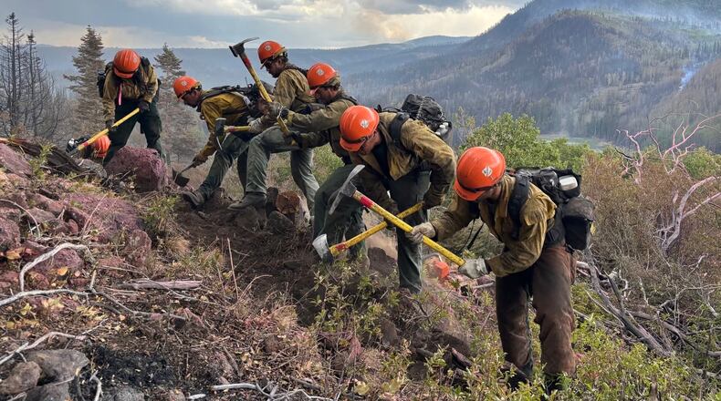 This undated image provided by the U.S. Forest Service Friday, June 26, 2026, shows firefighters responding to the Cottonwood Fire on Wednesday, June 24, 2026, above Birch Lake, near Beaver, Utah. (Mike McMillan/U.S. Forest Service via AP)