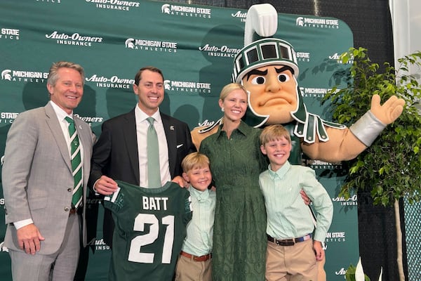 Michigan State athletic director J Batt, second from left, poses with MSU President Kevin Guskiewicz, left, Batt's wife Leah and sons and Sparty the mascot during a news conference, Wednesday, June 4, 2025, in East Lansing, Mich. (AP Photo/Larry Lage)