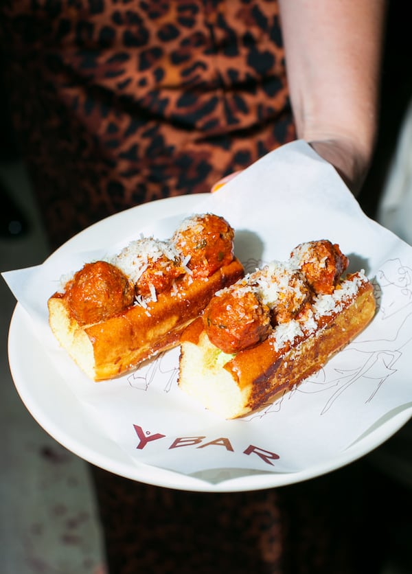 Two mini meatball subs are placed on a white Y Bar plate.
