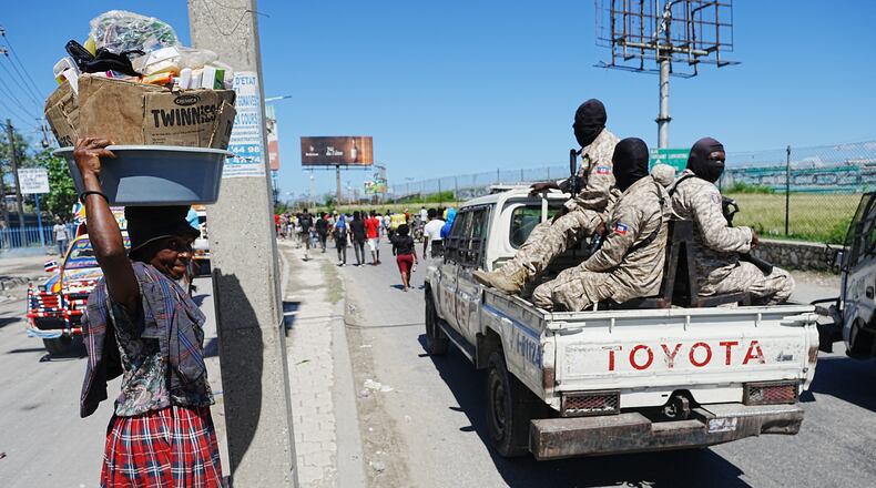 National Police patrol as factory workers march demanding a salary increase in Port-au-Prince, Haiti, Tuesday, April 14, 2026. (AP Photo/Odelyn Joseph)