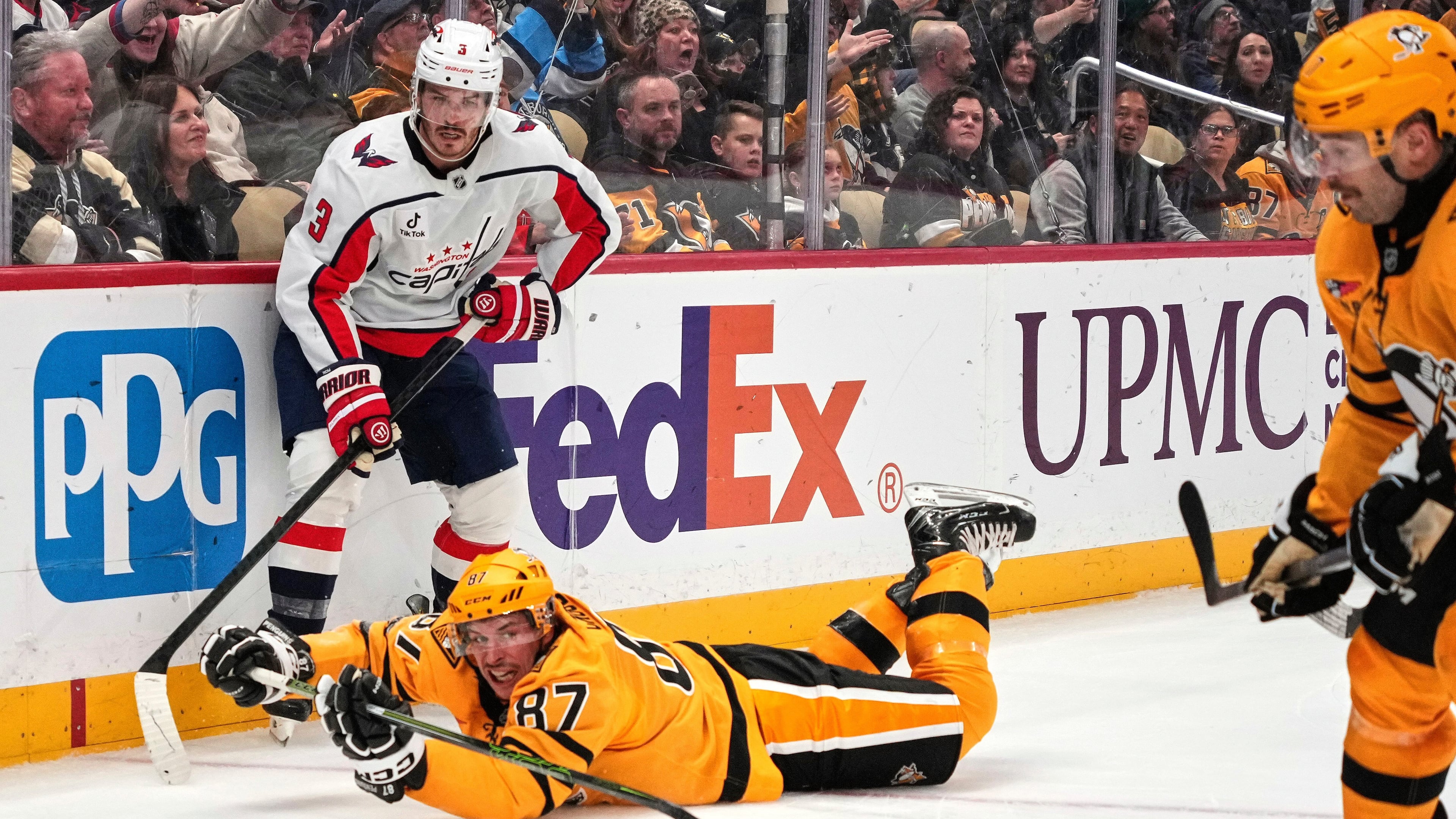 Pittsburgh Penguins' Sidney Crosby (87) gets of a pass to Bryan Rust, right, with Washington Capitals' Matt Roy (3) defending during the second period of an NHL hockey game in Pittsburgh, Thursday, Nov. 6, 2025. (AP Photo/Gene J. Puskar)