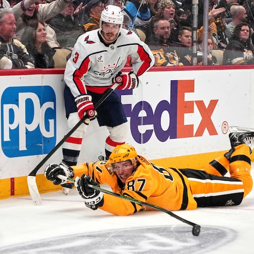 Pittsburgh Penguins' Sidney Crosby (87) gets of a pass to Bryan Rust, right, with Washington Capitals' Matt Roy (3) defending during the second period of an NHL hockey game in Pittsburgh, Thursday, Nov. 6, 2025. (AP Photo/Gene J. Puskar)