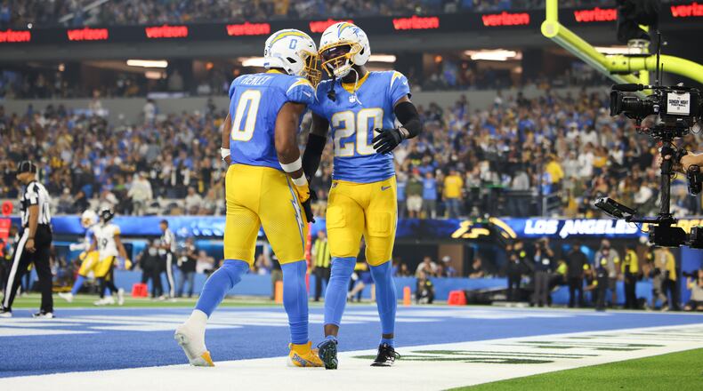 Los Angeles Chargers cornerback Cam Hart (20) and linebacker Daiyan Henley (0) celebrate after breaking up a touchdown pass during the second half of an NFL football game against the Pittsburgh Steelers Sunday, Nov. 9, 2025, in Inglewood, Calif. (AP Photo/Jessie Alcheh)