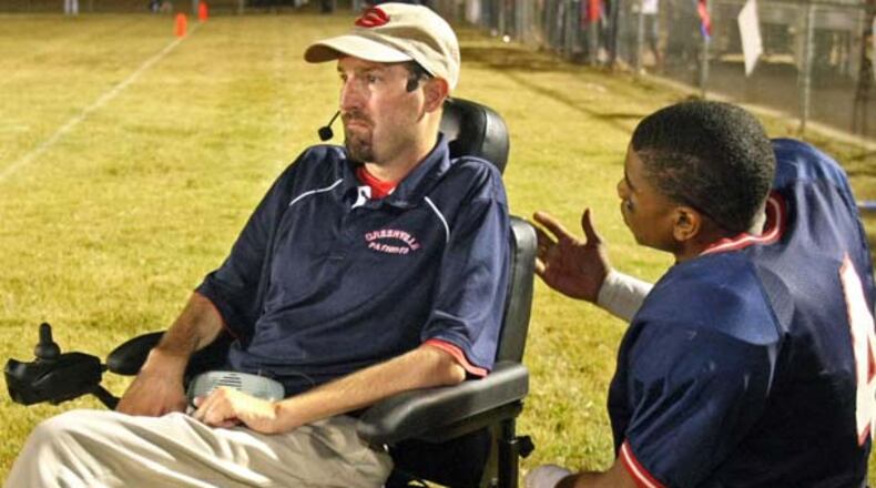 Using a motorized wheelchair, Greenville coach Jeremy Williams talks with quarterback Mario Alford during their win against Macon County in September 2010. Producers of a movie about the late Greenville football coach have hired a scriptwriter.