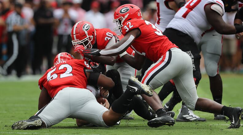Georgia defenders Tyler Clark (from left), Tae Crowder, and Monty Rice sack Arkansas State quarterback Logan Bonner during the first quarter in a NCAA college football game on Saturday, Sept. 14, 2019, in Athens. Georgia shut out Arkansas State 55-0. Curtis Compton/ccompton@ajc.com