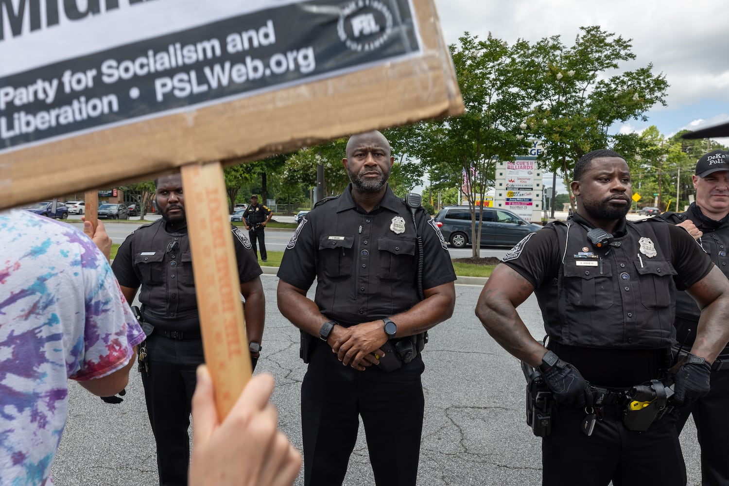 Demonstrators chant at police during a protest on ICE raids and deportation arrests on Chamblee-Tucker Road in Atlanta on Saturday, June 14, 2025. (Arvin Temkar / AJC)