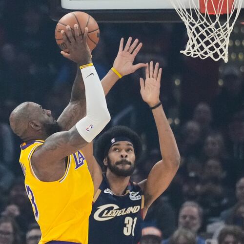 Los Angeles Lakers forward LeBron James left, shoots over Cleveland Cavaliers center Jarrett Allen (31) in the first half of an NBA basketball game in Cleveland, Wednesday, Jan. 28, 2026. (AP Photo/Sue Ogrocki)
