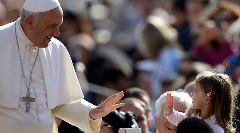 SMILE AND A WAVE--Pope Francis greets a child as he arrives in St. Peter's Square for his weekly general audience at the Vatican, Wednesday, April 1, 2015. (AP Photo/Gregorio Borgia)