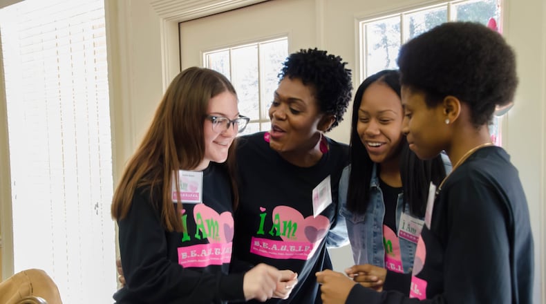 Tina Woodard sings as she teaches the lyrics of the I Am B.E.A.U.T.I.F.U.L. song to girls attending the annual Pink Pajama Jam recently at Lake Lanier. CONTRIBUTED