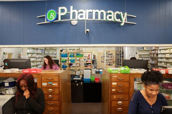 Pharmacy technicians Dylan Cheeks (foreground left) and Michelle Ola, and pharmacist Madison Coyne (back), work at Wender & Roberts Pharmacy in Atlanta on Aug. 10, 2026. The owner said it's tough to hire pharmacy techs, because many can't afford to live in Buckhead. (Arvin Temkar/AJC)