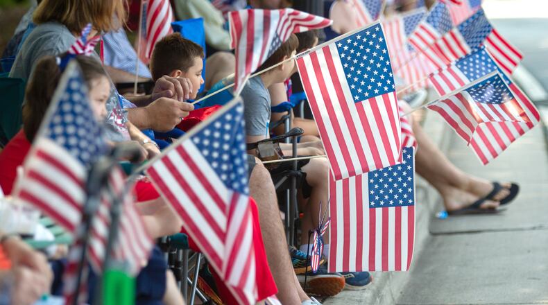 People line Roswell Street with their American flags during the Let Freedom Ring Parade in Marietta on Saturday, July 3, 2021. (Photo: Steve Schaefer for The Atlanta Journal-Constitution)
