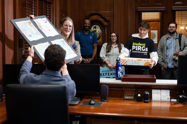 Jennette Gayer, the state director of Environment Georgia, and a coalition of supporters deliver artwork and petitions seeking protections for the Okefenokee Swamp to Gov. Brian Kemp’s office in Atlanta on Thursday. (Ben Gray for the AJC)