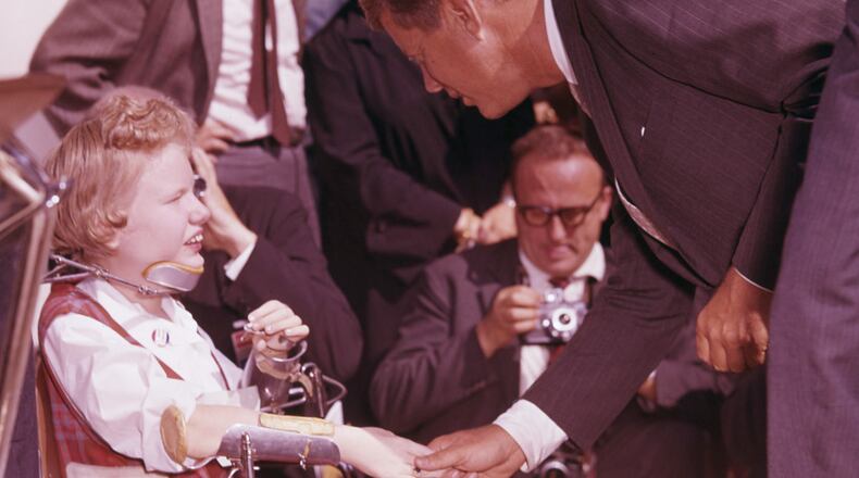 Then-Sen. John F. Kennedy meets with a disabled child in Warm Springs, Ga., on Sunday, Oct. 16, 1960. (AJC file)