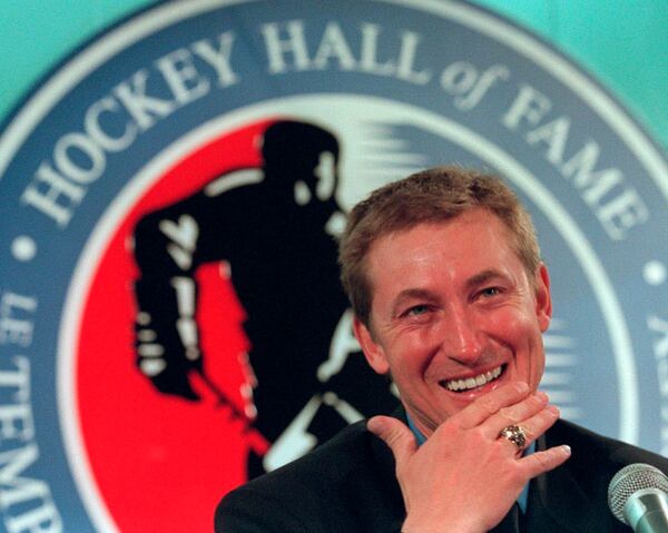 FILE - Hockey legend Wayne Gretzky laughs as he wears his new Hockey Hall of Fame ring during his induction ceremony at the Hall in Toronto, Nov. 22, 1999. (AP Photo/Frank Gunn, File)