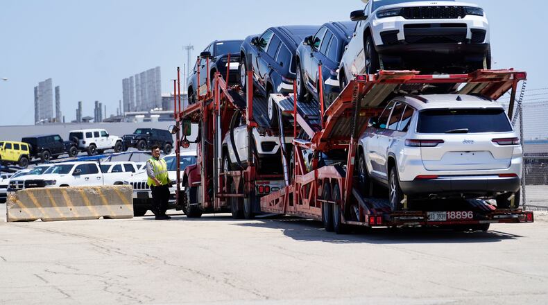FILE - A transport carrying new cars arrives at a Stellantis facility July 10, 2023, in Belvidere. Ill. (AP Photo/Charles Rex Arbogast, File)