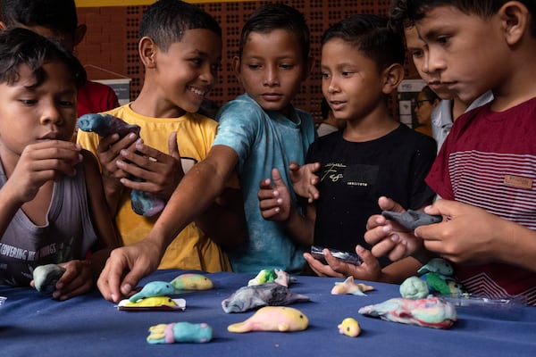 Children make manatee models out of Play-Doh during a trip to Emilio Goeldi Museum's scientific station in Para state, Brazil, Friday, March 21, 2025. (AP Photo/Jorge Saenz)
