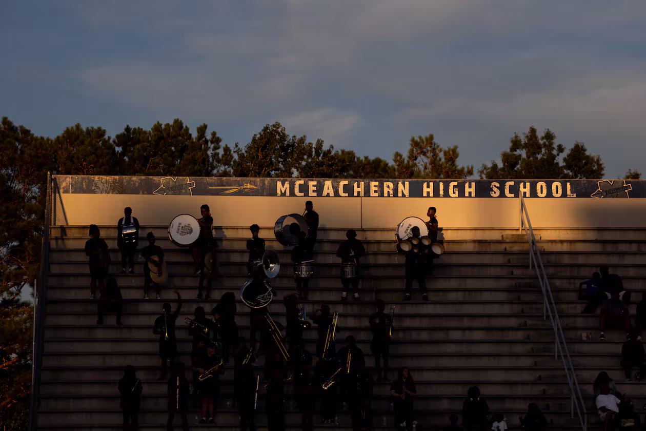 Fans are seen under the McEachern High School sign during a GHSA High School football game between Langston Hughes High School and McEachern High School at McEachern High School in Powder Springs, Georgia, on Friday, Aug. 26, 2022. (Jenn Finch for the AJC)