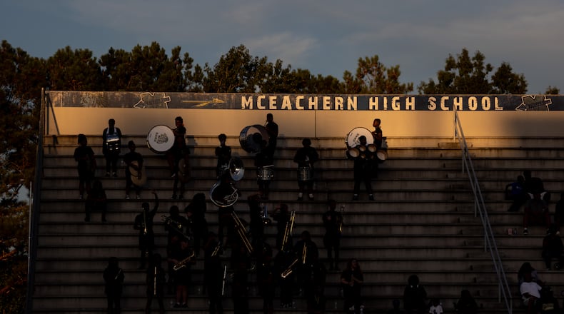 Fans are seen under the McEachern High School sign during a GHSA High School football game between Langston Hughes High School and McEachern High School at McEachern High School in Powder Springs, Georgia, on Friday, Aug. 26, 2022. (Jenn Finch for the AJC)