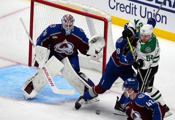 Dallas Stars center Mikael Granlund, right, struggles to redirect the puck as Colorado Avalanche defenseman Samuel Girard, center, protects goaltender Mackenzie Blackwood in the first period of Game 3 of an NHL hockey first-round playoff series Wednesday, April 23, 2025, in Denver. (AP Photo/David Zalubowski)