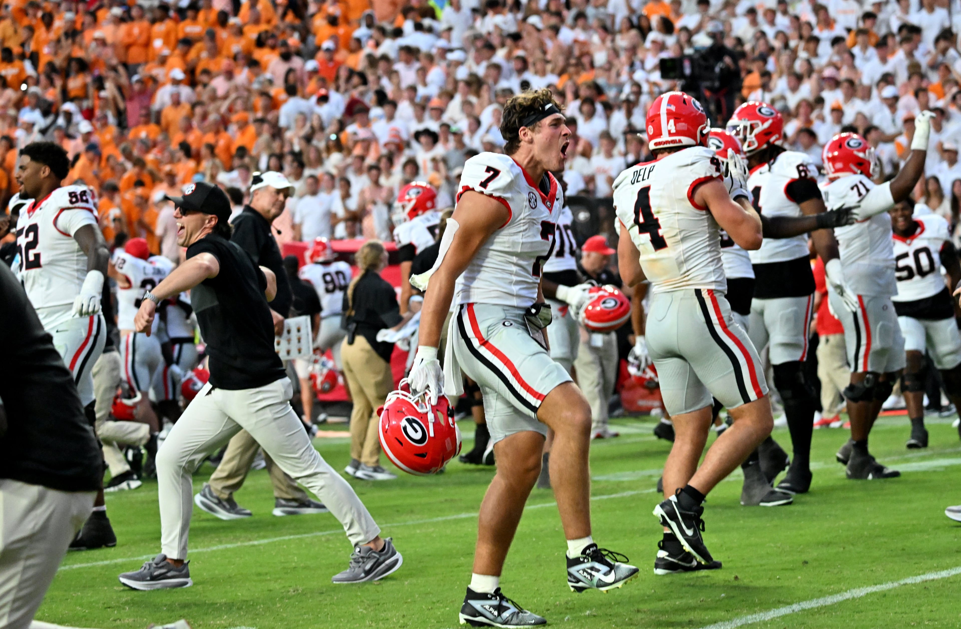 Georgia players and coaching staff celebrate after Georgia beat Tennessee 44-41 in overtime at Neyland Stadium on Saturday, Sept. 13, 2025, in Knoxville, Tenn. (Hyosub Shin/AJC)