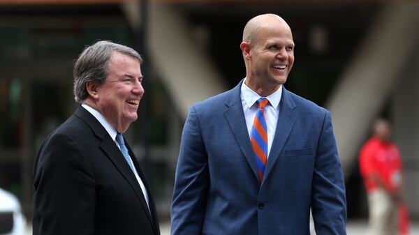 National Football Foundation President and CEO Steve Hatchell (left) and College Football Hall of Famer Danny Wuerffel react during the sign unveiling ceremony for the Chick-fil-A College Football Hall of Fame on Thursday, May 24, 2018, in Atlanta. (Jason Getz/AJC)